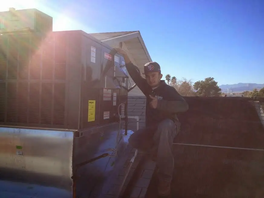 HVAC technician performing Air Duct Cleaning on a rooftop unit in Pendleton